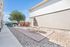 Charming outdoor area with picnic table, modern landscaping, and vibrant tree under a bright blue sky.