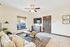 Bright and inviting living room with natural light, elegant ceiling fan, and tasteful decor, perfect for relaxation and entertainment.