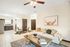 Bright and inviting open-concept living space featuring cozy seating, stylish decor, and a modern kitchen with dark cabinetry.