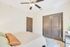 Cozy bedroom retreat with soft lighting, ceiling fan, and sleek doors complementing the tranquil ambiance.
