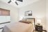 Cozy bedroom featuring a sleek ceiling fan, contemporary bedside lamps, and a large mirror above a stylish bed.