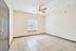 Bright and airy room with elegant tiled flooring and natural light streaming through blinds, complemented by a modern ceiling fan.