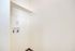 Bright utility nook in a modern apartment with sleek white walls and built-in connections for appliances.