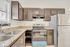 Modern kitchen with elegant dark cabinetry, granite countertops, stainless steel appliances, and a double sink with ample natural light.