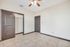 Bright room with elegant tile flooring and modern ceiling fan, featuring spacious closet space and sleek dark wood doors.