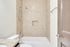 Chic bathroom showcasing elegant beige tiled walls, granite countertop, and modern fixtures for a touch of luxury.