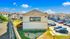 Charming apartment complex with ample parking, showcasing the vibrant Merida Vista branding under a clear blue sky.