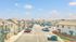 Charming apartment complex with classic architecture, ample parking, and vibrant landscaping under a clear blue sky.