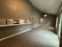 Spacious open-concept living room with vaulted ceilings, modern kitchen, and sleek hardwood flooring, perfect for stylish entertaining.
