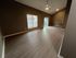 Spacious and modern living area with high ceilings, warm wood flooring, and large windows for abundant natural light.