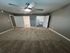 Cozy bedroom with plush carpet, modern ceiling fan, and ensuite bathroom featuring sleek fixtures and spacious closet.