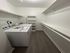 Spacious laundry room with modern washer and ample shelving, perfect for convenient storage and organization.