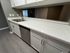 Modern kitchen with sleek white cabinetry, luxurious stone countertops, and stainless steel appliances.
