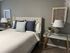 Cozy bedroom with an elegant tufted bed, plush cushions, and stylish bedside lamps, perfect for relaxation and comfort.