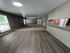 Inviting living space featuring modern wood flooring, plush carpeted area, and a sleek breakfast bar with a contemporary faucet.