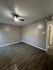 Inviting room featuring elegant wood flooring, neutral walls, and a modern ceiling fan, offering a cozy and versatile living space.