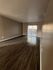 Spacious living room with elegant wood flooring and sliding glass doors opening to a bright patio.