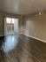Bright and inviting living room with sleek hardwood floors and large sliding glass doors leading to a private outdoor patio.