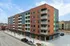 Modern apartment building with vibrant facade, featuring spacious balconies and large windows.