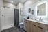 Elegant bathroom with modern shower, sleek vanity, and decorative wall art.