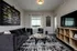 Modern living room with stylish decor, featuring a plush gray sofa, abstract artwork, and a sleek entertainment unit.