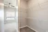 Bright and spacious walk-in closet with open shelving and modern carpeted floor.