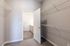 Bright walk-in closet with ample shelving and direct access to a modern bathroom.