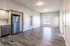 Spacious open-concept apartment with modern kitchen, stainless steel appliances, and sleek flooring.