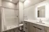 Contemporary bathroom with a sleek shower, modern vanity, and illuminated mirror.