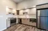 Modern kitchen with sleek stainless steel appliances, wood cabinets, and elegant lighting.