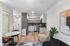View from furnished living room into kitchen and entryway