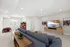 Modern living room with cozy plush seating, vibrant artwork, and a classic arcade game, perfect for entertainment and relaxation.