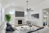 Modern living room with vaulted ceilings, featuring a cozy fireplace, elegant decor, and a large flat-screen TV, perfect for relaxation.