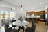 Elegant open-concept kitchen and dining area with marble table, stylish bar stools, and a cozy balcony view.