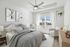 Bright and cozy bedroom with stylish decor, modern ceiling fan, and large window letting in natural light.