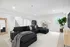 Inviting living room with sleek black sectional, chic decor, and a bright, airy atmosphere.
