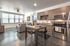 College Town, interior, kitchen, living room, large windows, table and chairs, wood cabinets, stainless steel microwave and stove/oven, couch, area rug