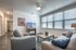 College Town, interior, living room, gray sofa and arm chair, coffee table, large windows, tv
