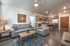 College Town, interior, living room, gray sofa and arm chair, area rug, coffee table, end table, lamp, dining room, chairs and table for 3, front door, kitchen, stainless steel, refrigerator, dishwasher, microwave, stove/oven, wood cabinets