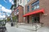 College Town, exterior, main entrance, red brick and white building, steps to door, large windows, red overhang, cars,