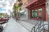 College Town, exterior, main entrance, red brick and white building, steps to door, large windows, red overhang, cars,