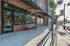 College Town, exterior, red brick building, wide sidewalk, bench, safety fence, palm tree, cars, people, large windows