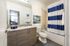 College Town, interior, bathroom, wood cabinets, large mirror, sink, toilet, shower/tub, blue and white shower curtain, tan tile shower surround