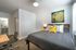 College Town, bedroom, bed, gray comforter, desk, chair, wall art, doorway to bathroom
