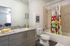 College Town, interior, bathroom, wood cabinets, large mirror, toilet, shower/tub, bright flower shower curtain