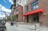 College Town, exterior, main entrance, red brick and white building, steps to door, large windows, red overhang, cars,