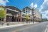 College Town, exterior, main entrance, street, side walk, steps, high arched overhang, red brick and white building, trees