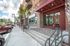 College Town, exterior, main entrance, red brick and white building, steps to door, large windows, red overhang, cars,