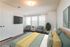 Contemporary bedroom with a comfortable bed, stylish armchairs, and large windows offering ample natural light.