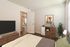 Inviting bedroom featuring modern furnishings, stylish decor, and a view into a bright living area.